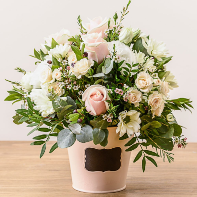 Dawn - Fresh and pretty arrangement featuring soft pink roses, white flowers and foliages, in a country style tin or wooden container.  This arrangement is made is oasis foam which makes it easy to care for, just add a little water to maintain fresh blooms all week long.

Suitable for a new baby gift, get well, thinking of you, tablecentre or a stylish anniversary gift this design is eternally popular on our website