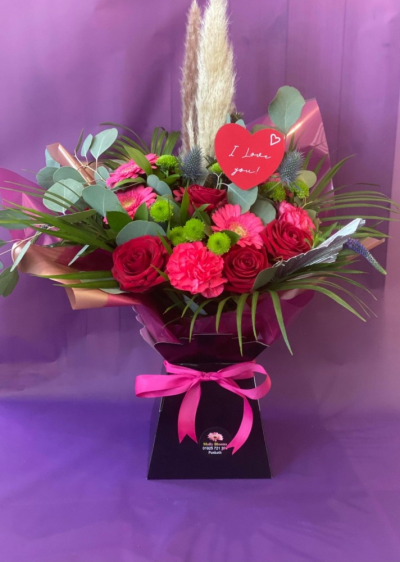Love Bomb - Molly Blooms Exclusive
A stunning Aqua bouquet containing six red roses, hot pink Germini, and a luxury assortment of dried flowers, spear palms, and pampas grass.

We are happy to upgrade your gift to 12 roses, more of everything, and, of course, a larger box, just choose the Luxury size.

Or for the ultimate 'Love Bomb' how about 18 red roses and lashings of beautiful pampas,palm spears, Germini, exotic foliage, and pizzazz!!