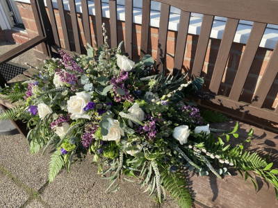Eco friendly Casket Spray - Funeral flowers,  Eco friendly, plastic and oasis-free, and kinder to the environment.

Our eco caskets sprays and funeral tribute are designed especially for your loved one. They can be made in a variety of colours and include any specially requested flowers that are in season.

The main difference is that we use a compostable base, natural moss, and twine in place of the usual plastic tray and oasis foam in their construction.

As a result the flowers tend to sit in a looser, more relaxed way, and this technique is ideally suited to a wilder, natural or woodland vibe, rather than a very uniform formal arrangement.